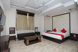 sypialnia z łóżkiem, telewizorem i kanapą w obiekcie Hotel Subhadra Residency w mieście Anūpnagar