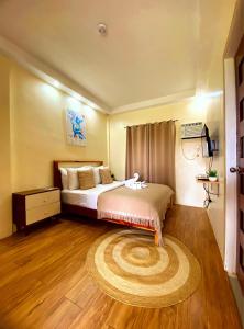 um quarto com uma cama e um tapete grande em Villa Alessandra Homestay em Moalboal