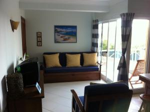 sala de estar con sofá azul y TV en Apartamento Navegantes, en Sintra