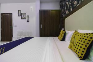 a bedroom with a large bed with yellow and blue pillows at SPOT ON Hotel White Rose in Zirakpur