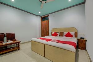 - une chambre avec un grand lit et des oreillers rouges dans l'établissement OYO Flagship Hotel Sunraj, à Rānchī