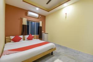 GauripurにあるFlagship Hotel Palki Palace Near Netaji Subhash Chandra Bose International Airportのベッドルーム1室(赤い枕のベッド1台、窓付)
