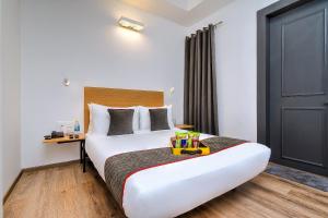 a hotel room with a large white bed and a door at OYO Townhouse 607 Paschim Vihar in New Delhi