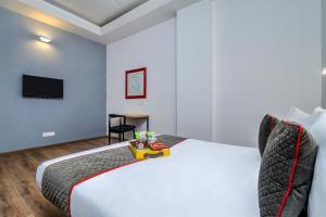 a bedroom with a large white bed and a table at OYO Townhouse 607 Paschim Vihar in New Delhi