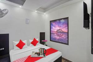 a bedroom with two beds with red pillows at OYO Flagship Kwins Residency in Ghaziabad