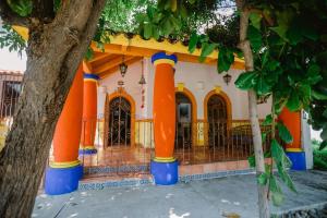 uma casa com colunas cor-de-laranja à frente. em Casa Oaxaqueña em Santa Cruz, Huatulco
