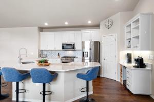 a kitchen with white cabinets and blue bar stools at HomeAway Vacation Rental - Eagle Crest in Redmond
