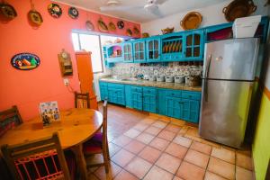 uma cozinha com armários azuis, uma mesa e um frigorífico em Casa Oaxaqueña em Santa Cruz, Huatulco