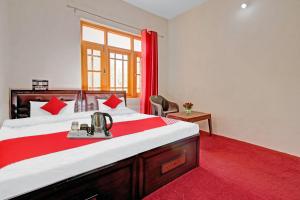 a bedroom with a large bed with a red rug at OYO Green Resort in Gandbal