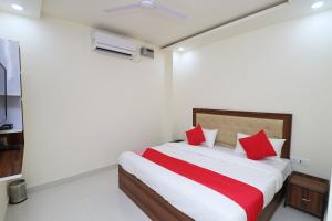 a bedroom with a large bed with red pillows at OYO Hotel Dezzire in Ballabgarh