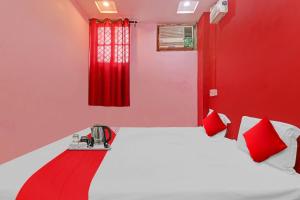 a red room with a bed and red curtains at Flagship Hotel Narayani Palace in Kānpur