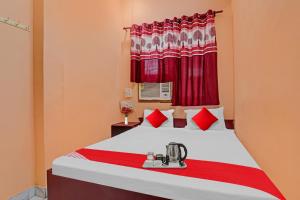 a bedroom with a large bed with red curtains at Flagship Hotel Narayani Palace in Kānpur