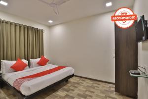 a bedroom with a bed with a red sign on the wall at Hotel O Ripple Mall in Surat