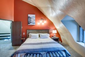 a bedroom with a large bed with an orange wall at Wisconsin Vacation Rental 1 Mi to Road America! in Plymouth