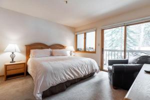 um quarto com uma cama, um sofá e janelas em Townsend Place Ski In Ski Out Access em Beaver Creek