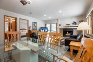 a living room with a glass table and a fireplace at Townsend Place Ski In Ski Out Access in Beaver Creek