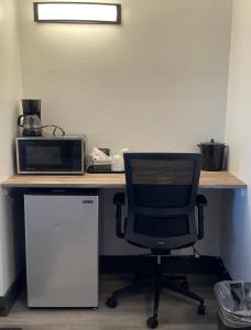 a desk with a computer and a chair and a microwave at Purple Sage Motel in Panguitch +10 photos