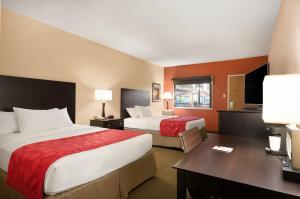 a hotel room with two beds and a desk at Red Lion Hotel Gillette in Gillette