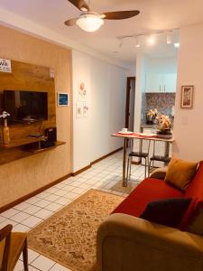 a living room with a red couch and a kitchen at Apart. Praia da Costa Premium in Vila Velha