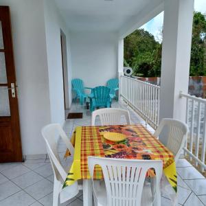 a table and chairs on the balcony of a house at L IXORA VOUS ACCEUILLE in Sainte-Luce