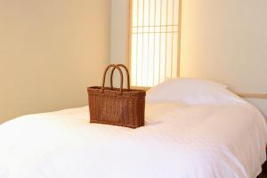 a basket sitting on top of a white bed at 蓼科BASE kitchen,spa&hotel in Chino