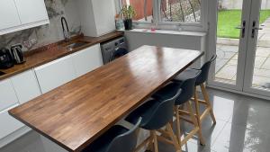 uma cozinha com uma mesa de madeira e algumas cadeiras em Stay near Southmead Hospital and Airbus em Bristol