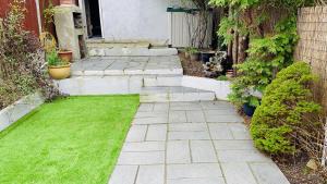 a patio with grass and steps to a house at Stay near Southmead Hospital and Airbus in Bristol