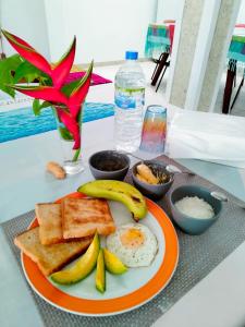 Backpacker Galle Hostel في غالي: طبق برتقالي من طعام الإفطار مع البيض والخبز المحمص