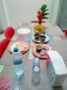 Backpacker Galle Hostel في غالي: طاولة مع أطباق من الطعام وزجاجة من الماء