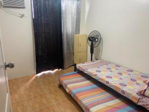 sypialnia z łóżkiem w rogu pokoju w obiekcie Staycation @Bali Oasis 2- 2BR unit with sunset view w mieście Manila