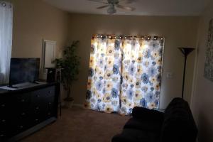 a living room with a curtain with flowers on it at "Mentor Place" a 4 bedroom home in the heart of a lake community min away from lot's activities in Mentor