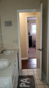 a white bathroom with two sinks and a hallway at "Mentor Place" a 4 bedroom home in the heart of a lake community min away from lot's activities in Mentor