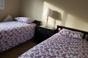 a bedroom with two beds and a lamp on a night stand at "Mentor Place" a 4 bedroom home in the heart of a lake community min away from lot's activities in Mentor