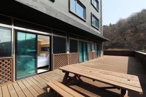 a wooden deck with a wooden picnic table on a building at Incheon Wolmido Dubai Tourist Hotel in Incheon