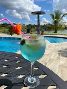 a drink sitting on a table next to a pool at Pousada Dona Tereza in Guapé