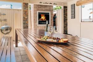 a table with a plate of food and wine glasses at Entertainment Haven 900m to the Beach in Kawana Waters