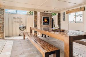 a dining room with a bench and a fireplace at Entertainment Haven 900m to the Beach in Kawana Waters