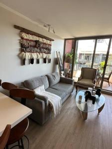 a living room with a couch and a table at Hermoso apartamento con piscina cercano al centro in Pucón