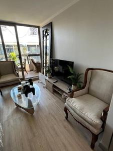 a living room with a couch and a coffee table at Hermoso apartamento con piscina cercano al centro in Pucón