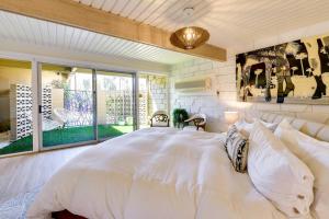 a bedroom with a large white bed and a balcony at Mid-Century El Paseo Condo in Iconic Sandpiper! in Palm Desert +17 photos