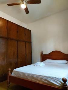 um quarto com uma cama, uma ventoinha de tecto e armários de madeira em CASA NONO ZENON em La Rioja