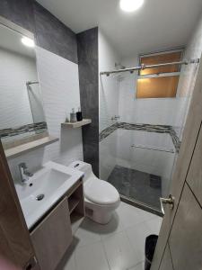 y baño con aseo, lavabo y ducha. en Apartamento para descansar en Duitama