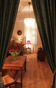 una sala de estar con cortinas verdes y una mesa con flores en Refugium der Liebe in Berlin, en Berlín