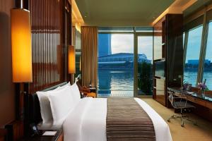 a hotel room with a bed and a view of the water at The Fullerton Bay Hotel Singapore in Singapore