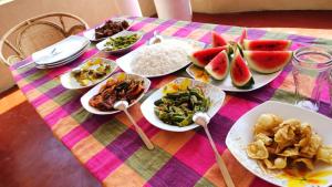 una mesa con platos de comida en una mesa en Dinuli home stay, en Ahungalla