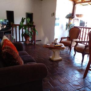 sala de estar con sofá, mesa y sillas en Mi Casa en Barichara, en Barichara