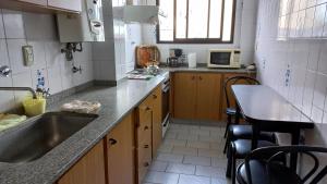 uma cozinha com um lavatório, uma mesa e um micro-ondas em Departamento para vacacionar em Mar del Plata