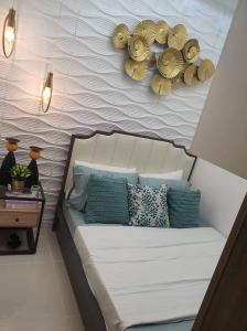 1 dormitorio con 1 cama con almohadas azules y pared en Coast Residence 4026 PENTHOUSE 1 Bedroom Condo with Wifi & Netflix en Manila