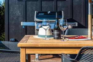 黑潭的住宿－Whare Iti，一张桌子,上面放着一瓶葡萄酒和两杯酒