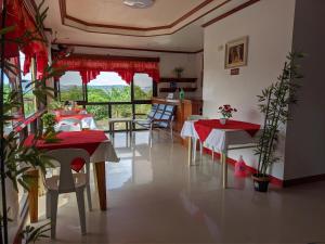 La Casa Milagrosa في كورون: غرفة معيشة مع طاولتين وكراسي ومطبخ